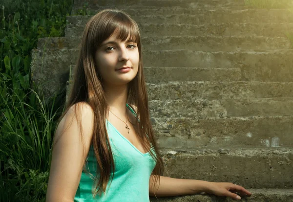 Beautiful Christian girl sitting on stairs — Stock Photo, Image