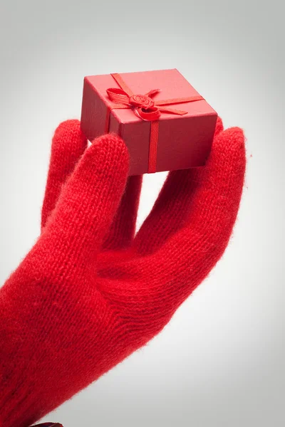 Hand schenkt rote Schachtel mit Geschenk über grau — Stockfoto