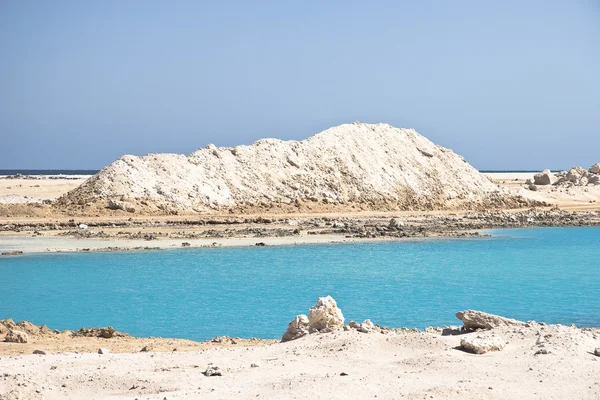 Úžasné modré jezero mezi pískem a skálami — Stock fotografie