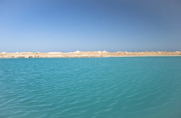 모래와 바위 사이에 있는 놀라운 푸른 호수 — 스톡 사진