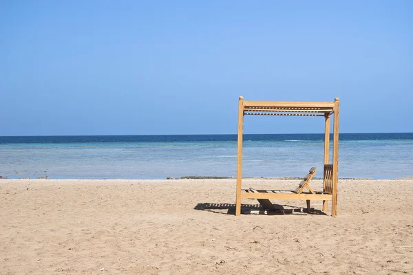 stock image Wooden beach lounge chairs along the shoreline