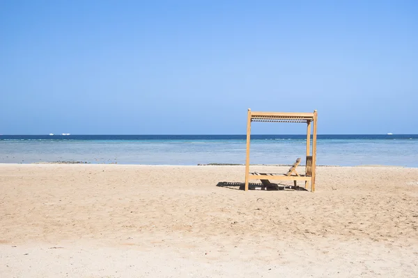 stock image Wooden beach lounge chairs along the shoreline