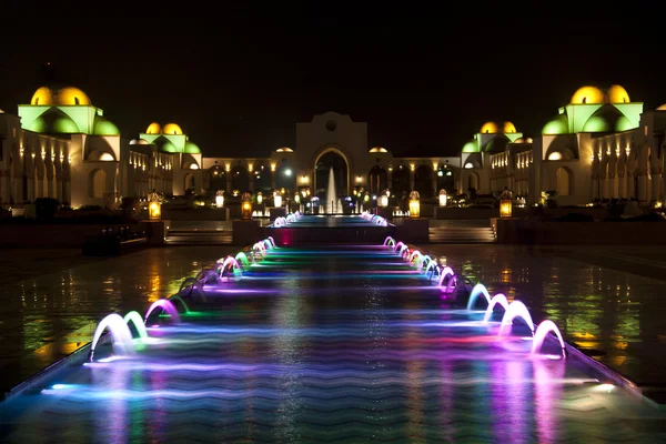 Tančící vícebarevná fontána v tmavé noci — Stock fotografie