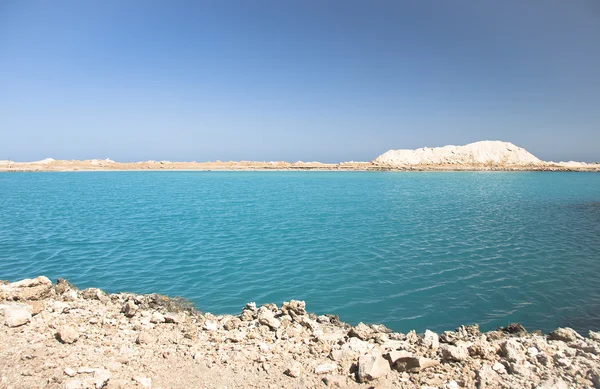 Erstaunlich blauer See zwischen Sand und Felsen — Stockfoto