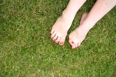kadının çıplak ayakları yeşil çimenlerin üzerinde