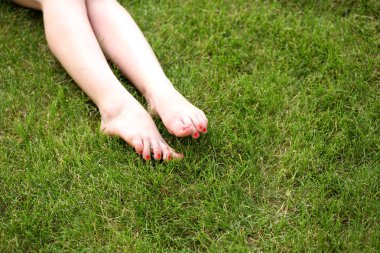 kadının çıplak ayakları yeşil çimenlerin üzerinde