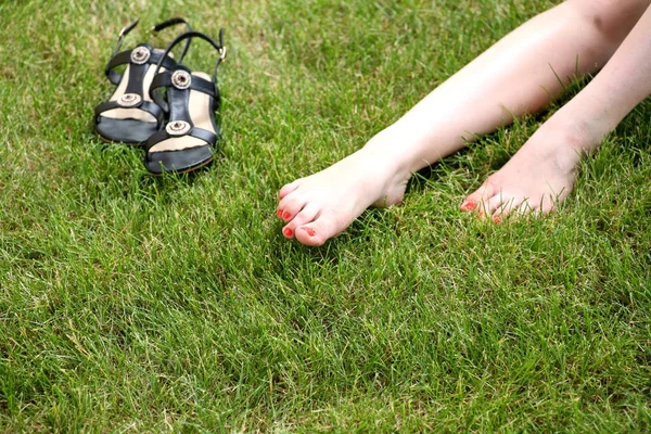 Womans bare feet on green grass — Stock Photo, Image