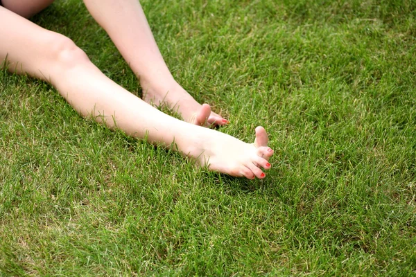 Womans bare feet on green grass — Stock Photo, Image