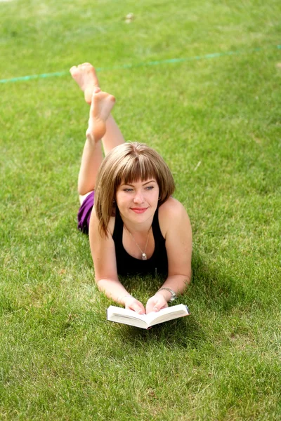 Piękna młoda kobieta, czytanie książki na zewnątrz — Zdjęcie stockowe