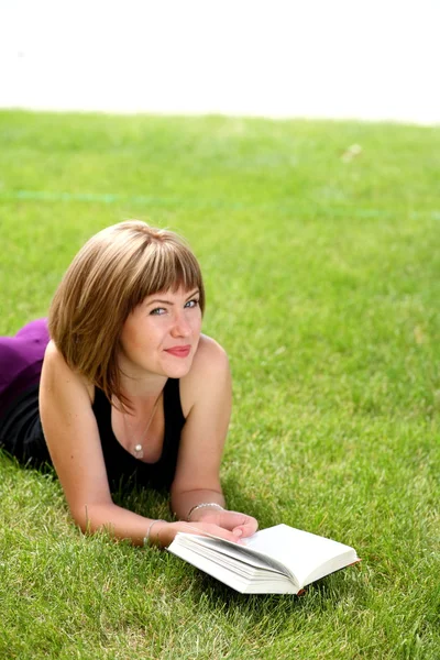 Beautiful young female reading the book outdoors — Stock fotografie