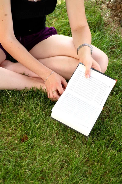 Fiatal, boldog asszony olvasás közben egy könyvet — Stock Fotó