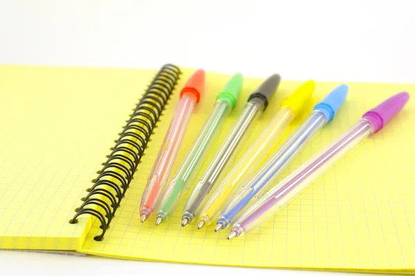 Bolígrafos de color en el libro de escritura amarillo —  Fotos de Stock