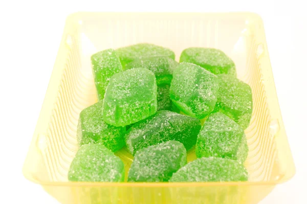 Green fruit jelly in yellow case — Stock Photo, Image