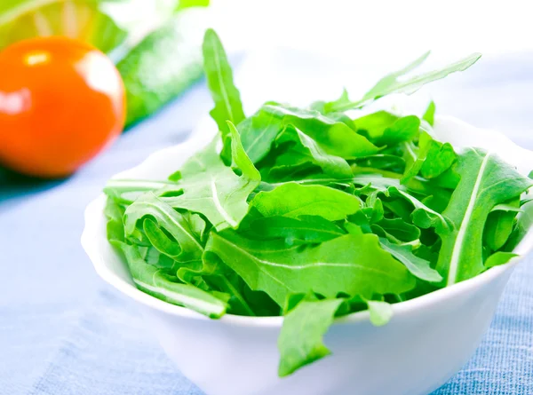 Groene rucola verse salade in witte kom — Stockfoto