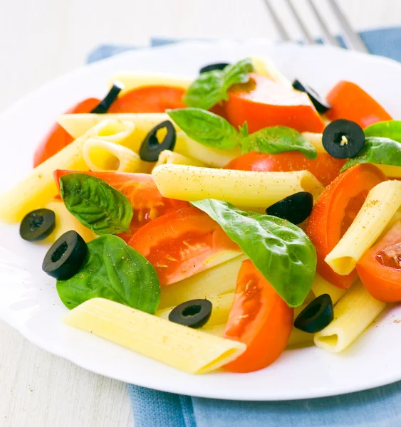 Salada de macarrão com tomate e folhas de manjericão fresco — Fotografia de Stock