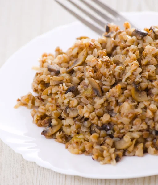 stock image Buckwheat porridge with mushrooms on plate