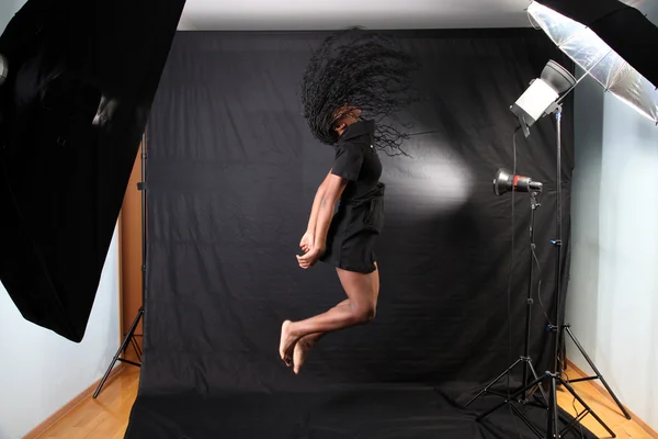 Donna afro-americana che salta in studio fotografico — Foto Stock