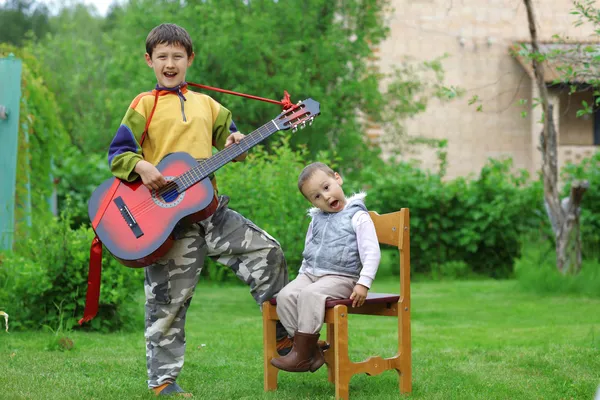 Dwóch chłopców śmieszne muzyka uczeń śpiewa i gra gitara bas Zdjęcie Stockowe