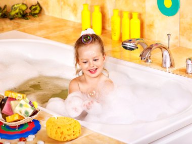 Child washing in bubble bath . clipart