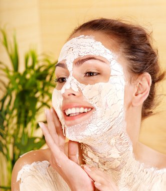 Woman with clay facial mask. clipart