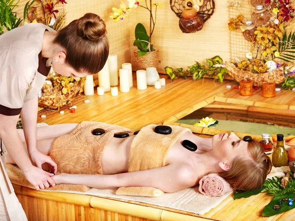 Kvinnfolk som får massasje av steinterapi  . – stockfoto