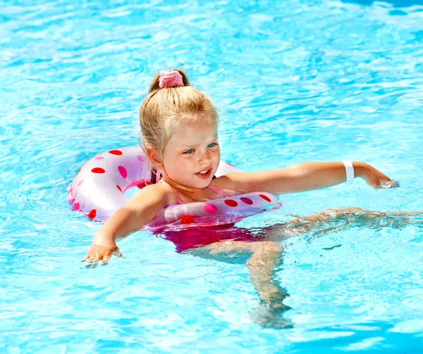 Kind zittend op opblaasbare ring in zwembad. — Stockfoto