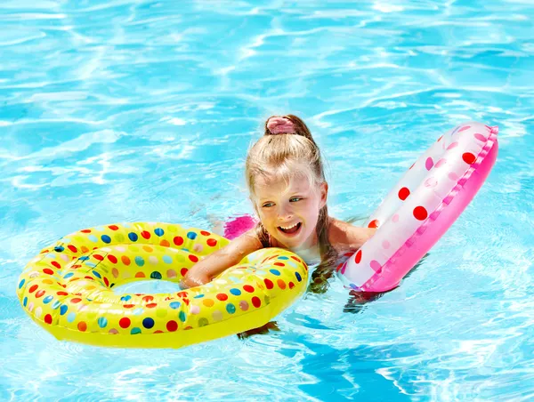 Kind zittend op opblaasbare ring in zwembad. — Stockfoto