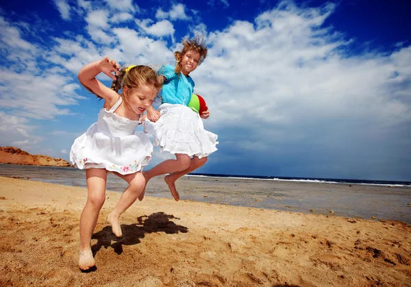 Niños jugando en la playa con pelota . — Foto de Stock