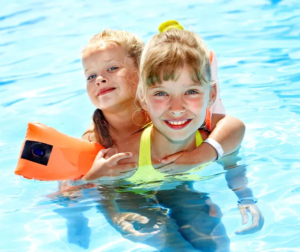 Bambino con bracciali in piscina — Foto Stock