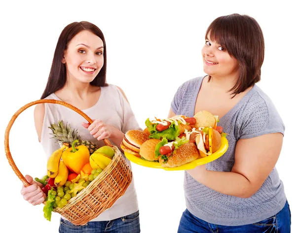 Mulheres escolhendo entre frutas e hambúrgueres . — Fotografia de Stock