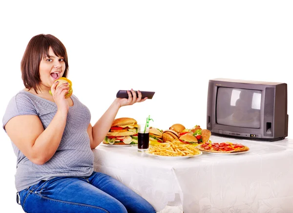 Mujer comiendo comida rápida y viendo la televisión . —  Fotos de Stock
