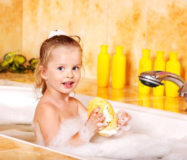 Child washing in bubble bath . clipart