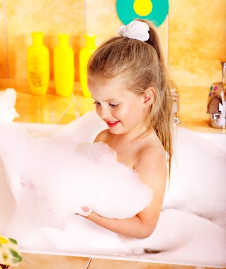 Child washing in bubble bath . clipart