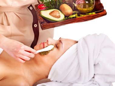 Woman getting facial mask in spa . clipart