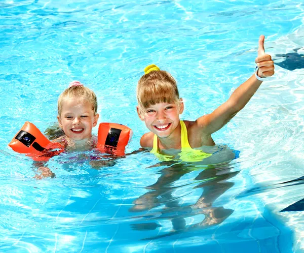 Kind mit Armbinden im Schwimmbad. — Stockfoto