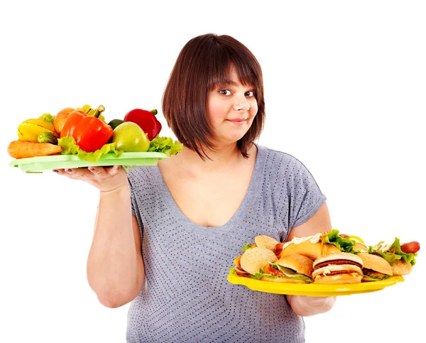 Frau hat die Wahl zwischen Obst und Hamburger. — Stockfoto