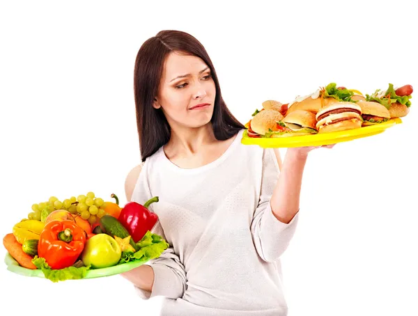 Frau hat die Wahl zwischen Obst und Hamburger. — Stockfoto