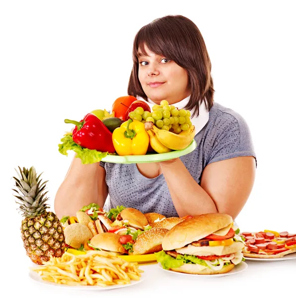 Kvinnan att välja mellan frukt och hamburgare. — Stockfoto