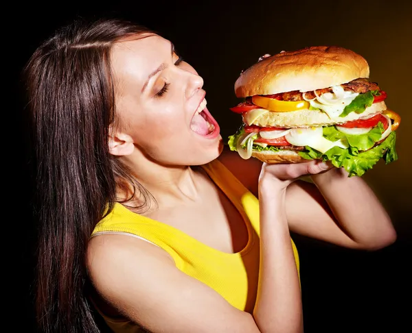 Frau beißt Hamburger. — Stockfoto