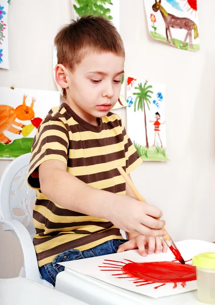Παιδί με την εικόνα και το πινέλο σε αίθουσα παιχνιδιών. — Φωτογραφία Αρχείου