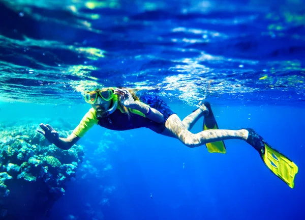 Kind scuba duiker met groep koraal vissen. — Stockfoto