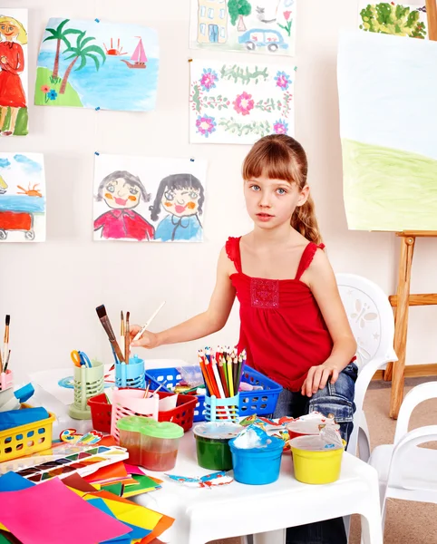 小女孩用图片和游戏室中的画笔 — 图库照片