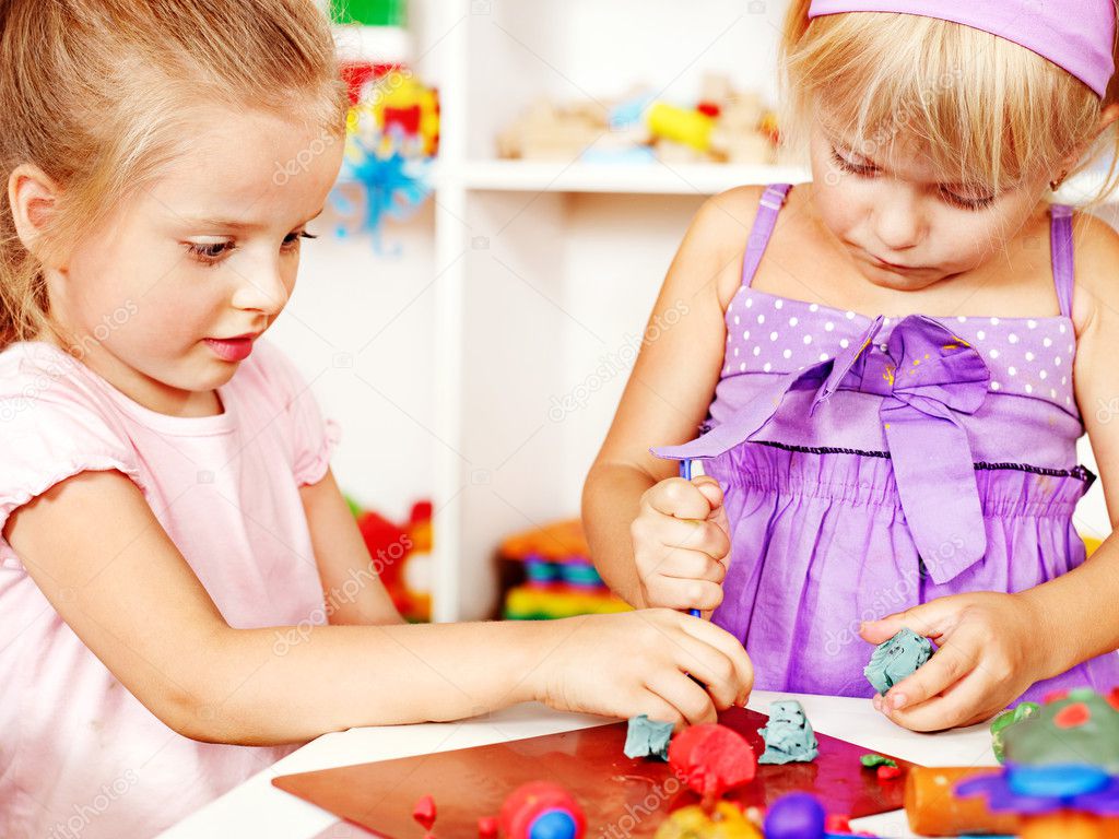 Children playing plasticine in kindergarten