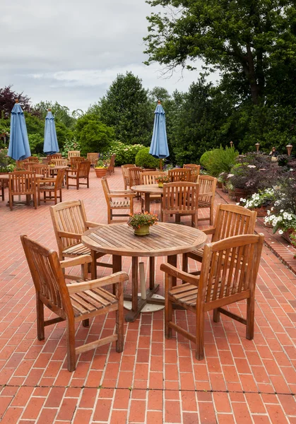 Teak patio masa ve sandalye tuğla güverte — Stok fotoğraf