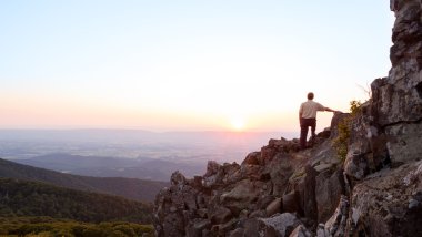 Senior man watches sunrise over blue ridge clipart