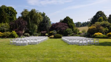 Rows of wooden chairs set up for wedding clipart