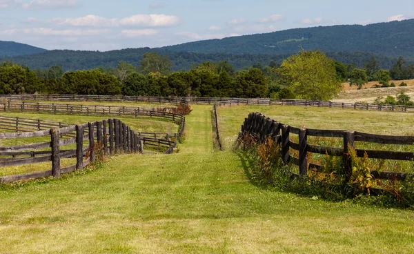 Rolling meadows with wooden fences and hills — Stock Photo, Image