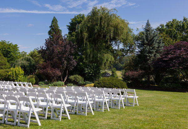 Rows of wooden chairs set up for wedding