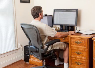 Senior male working in home office clipart