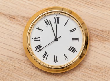 Brass small watch or clock on wood table clipart